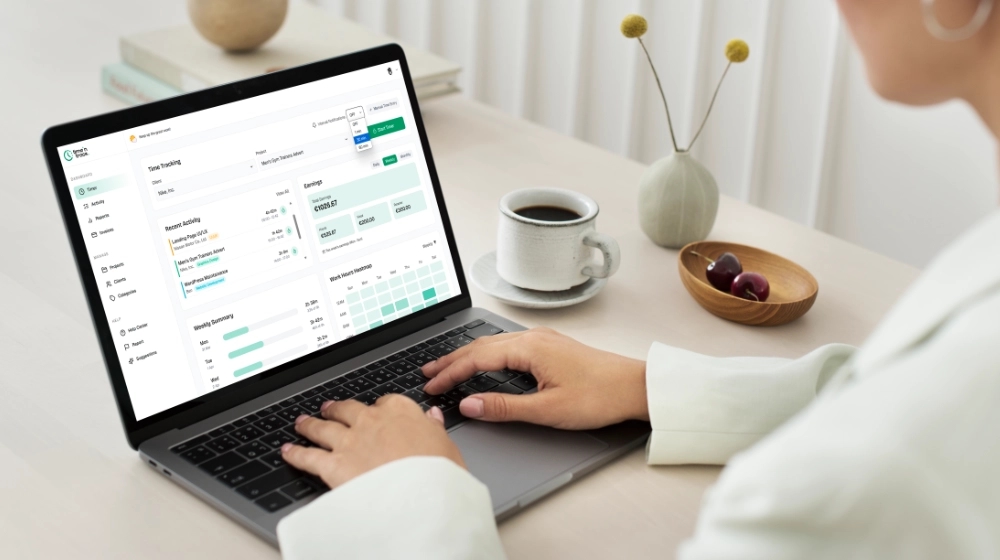 Freelancer using the Time 'N Track dashboard on a laptop